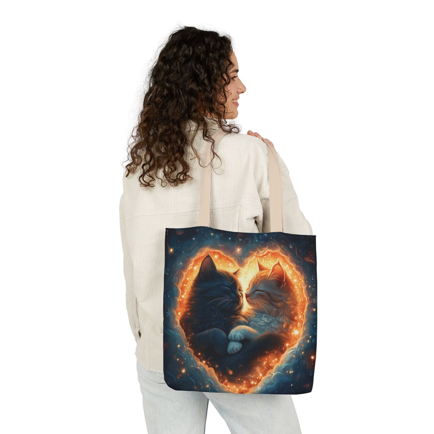 A vibrant heart composed of swirling stardust cradles two cuddling cats against a backdrop of a deep, colorful galaxy. This all-over print design covers the entirety of the Celestial Embrace Tote Bag.