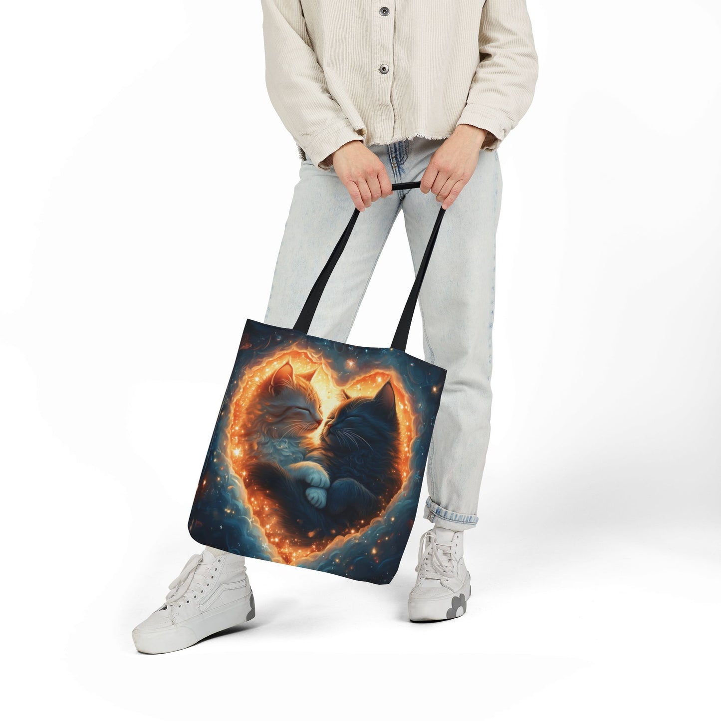 A vibrant heart composed of swirling stardust cradles two cuddling cats against a backdrop of a deep, colorful galaxy. This all-over print design covers the entirety of the Celestial Embrace Tote Bag.