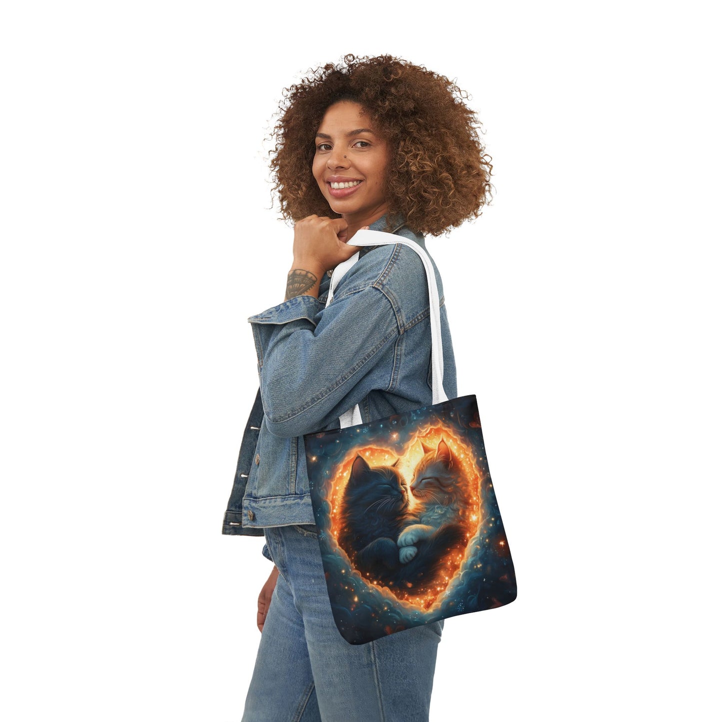 A vibrant heart composed of swirling stardust cradles two cuddling cats against a backdrop of a deep, colorful galaxy. This all-over print design covers the entirety of the Celestial Embrace Tote Bag.