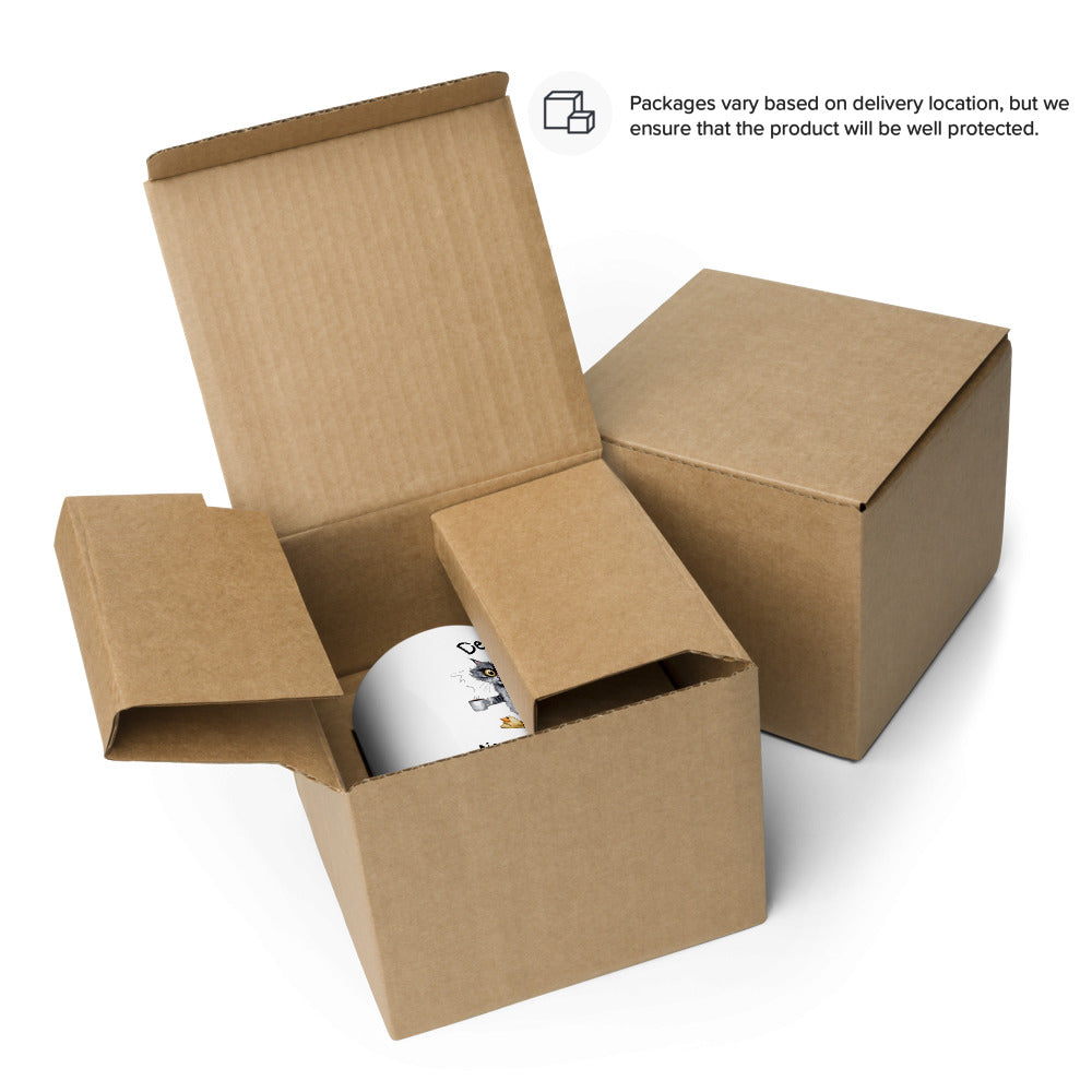 A white mug featuring a sleepy cat graphic displayed in an open box.