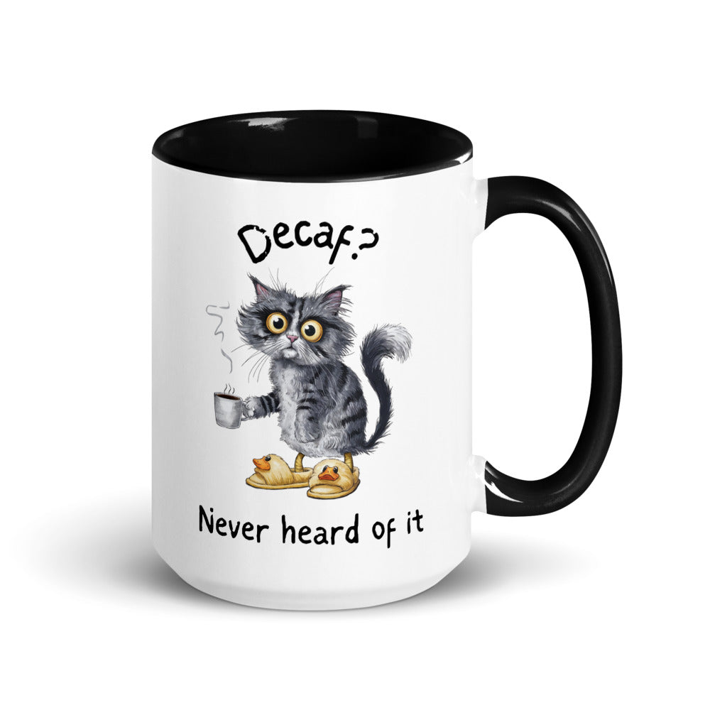 A white and black mug featuring an exhausted looking cat wearing yellow slippers with duck faces on them. The cat is holding a steaming mug of coffee. The text on the mug reads "Decaf? Never Heard of It."
