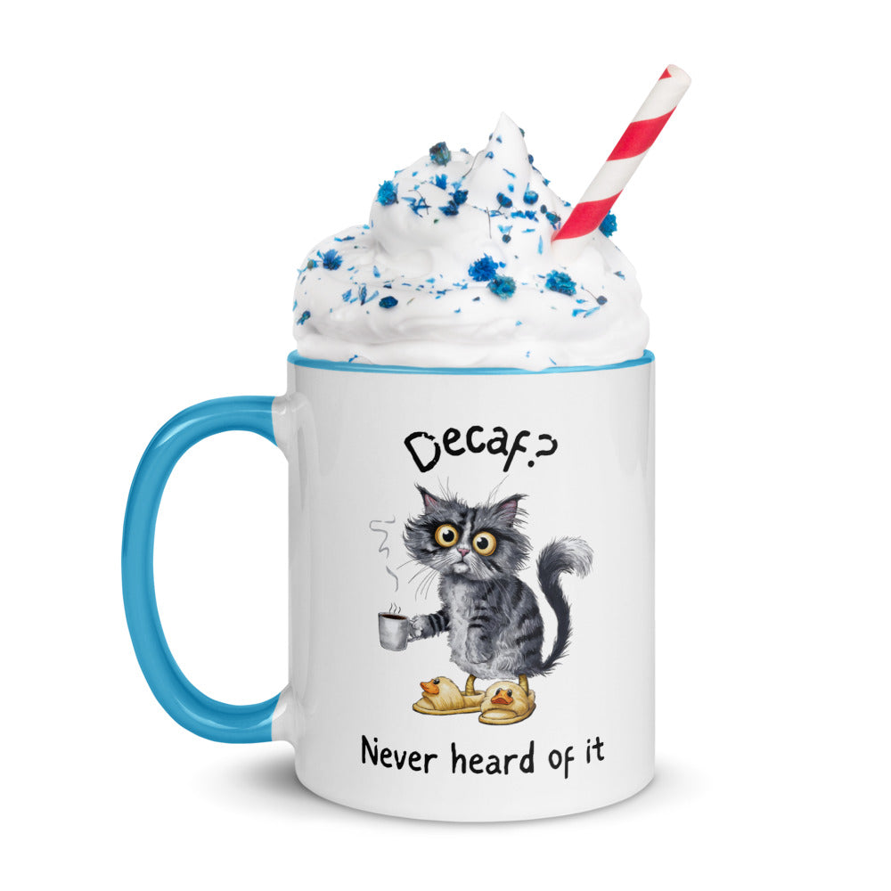 A white and light blue mug featuring an exhausted looking cat wearing yellow slippers with duck faces on them. The cat is holding a steaming mug of coffee. The text on the mug reads "Decaf? Never Heard of It."