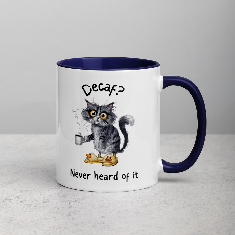 A white and dark blue mug featuring an exhausted looking cat wearing yellow slippers with duck faces on them. The cat is holding a steaming mug of coffee. The text on the mug reads "Decaf? Never Heard of It."