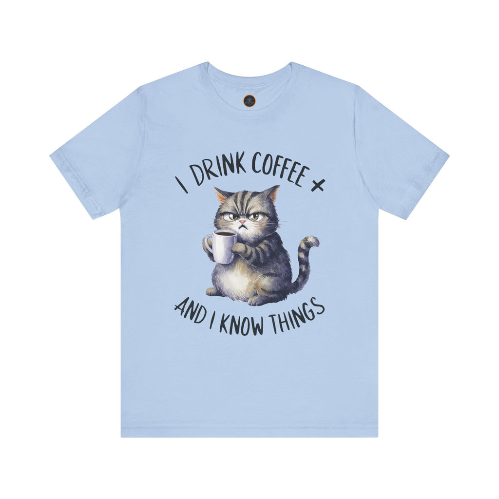 A crew neck t-shirt with the text 'I DRINK COFFEE AND I KNOW THINGS' and an illustration of grumpy a cat holding a coffee cup.