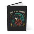 Black notebook with a cat and rose design on the cover, featuring the text 'Ink & Whiskers'.