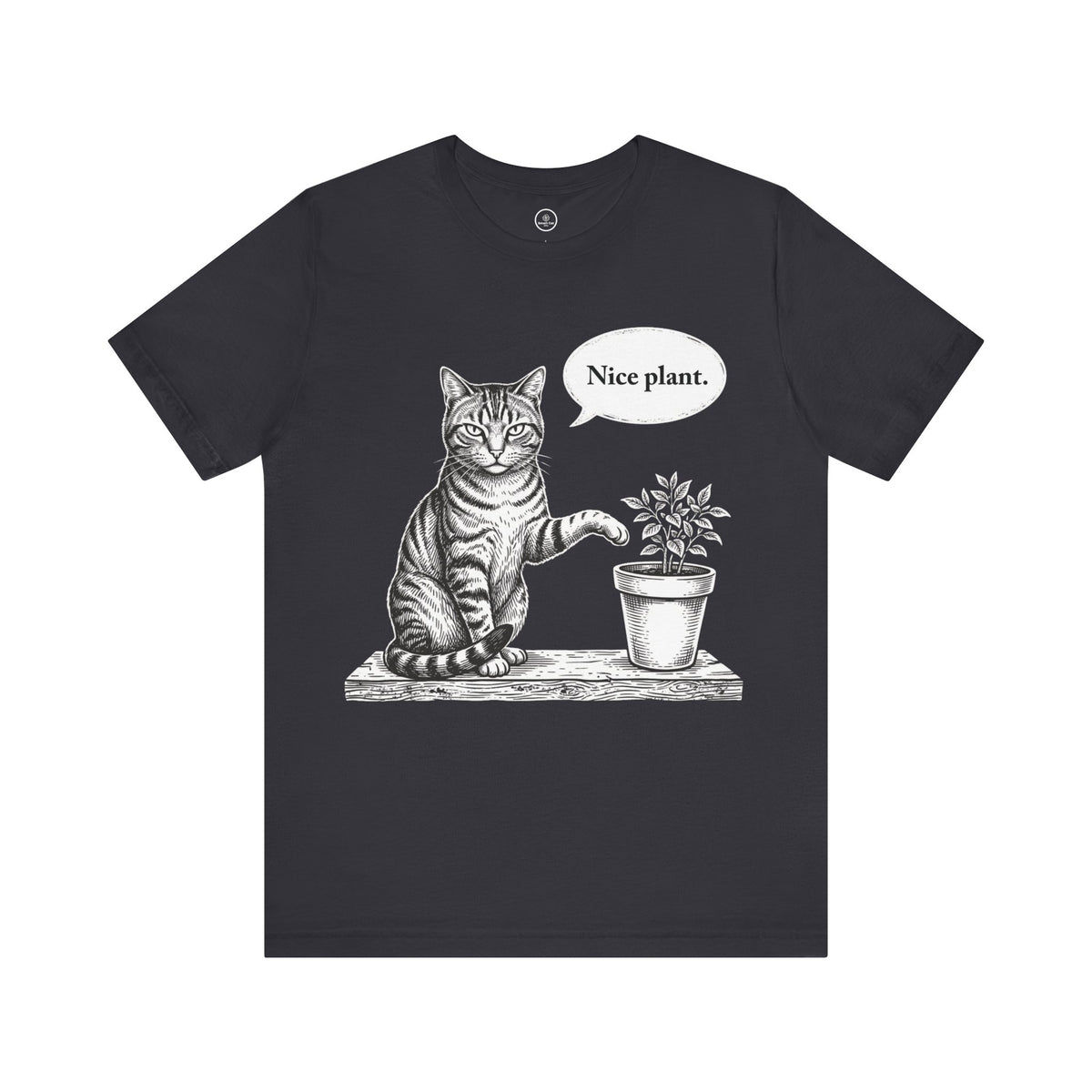 A dark grey short-sleeve crewneck t-shirt featuring a black and white sketch of a cat sitting next to a potted plant with a speech bubble that says 'Nice plant.' on a plain white background.