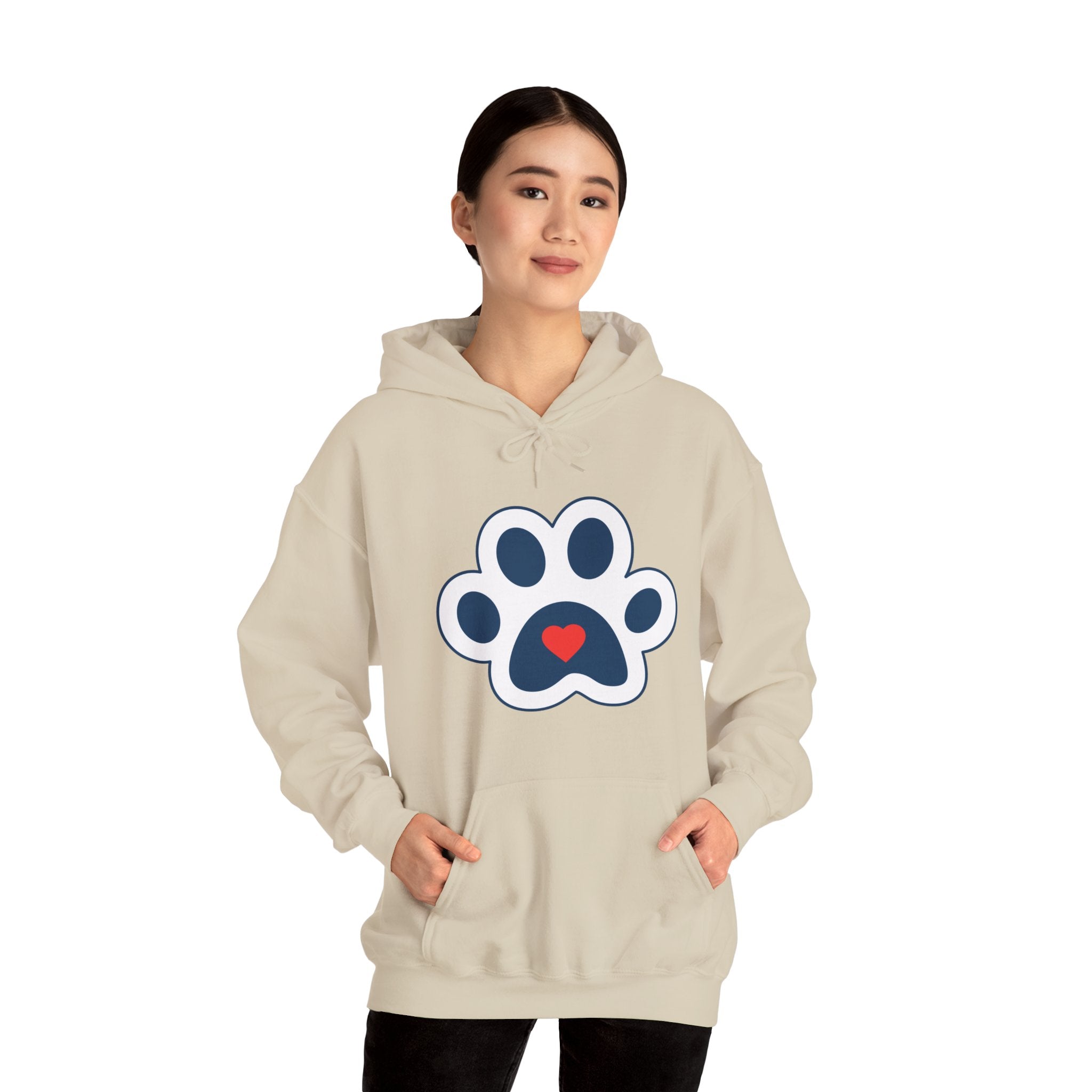 Woman in beige Heart In Paw hoodie: Blue and white cat paw graphic with a red heart in the center.