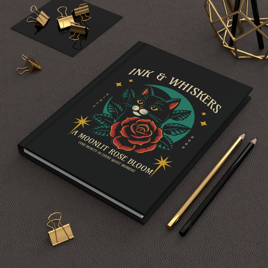 Black notebook with a cat and rose design on the cover, featuring the text 'Ink & Whiskers'.