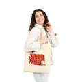 Woman holding a beige tote bag with red and white 'Dope Cat' text and cat graphics 
