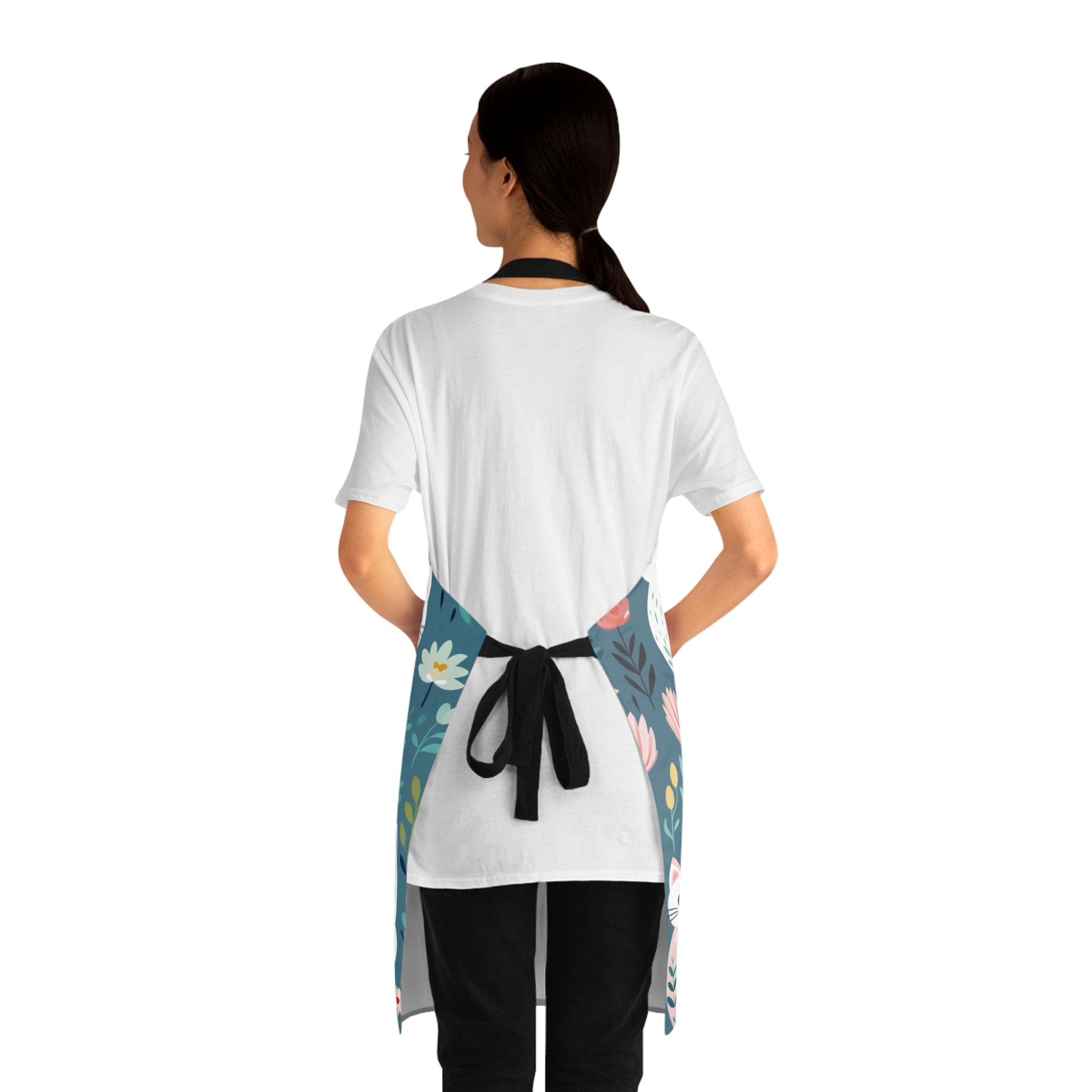 Back view of a model wearing a colorful apron with cat and floral design
