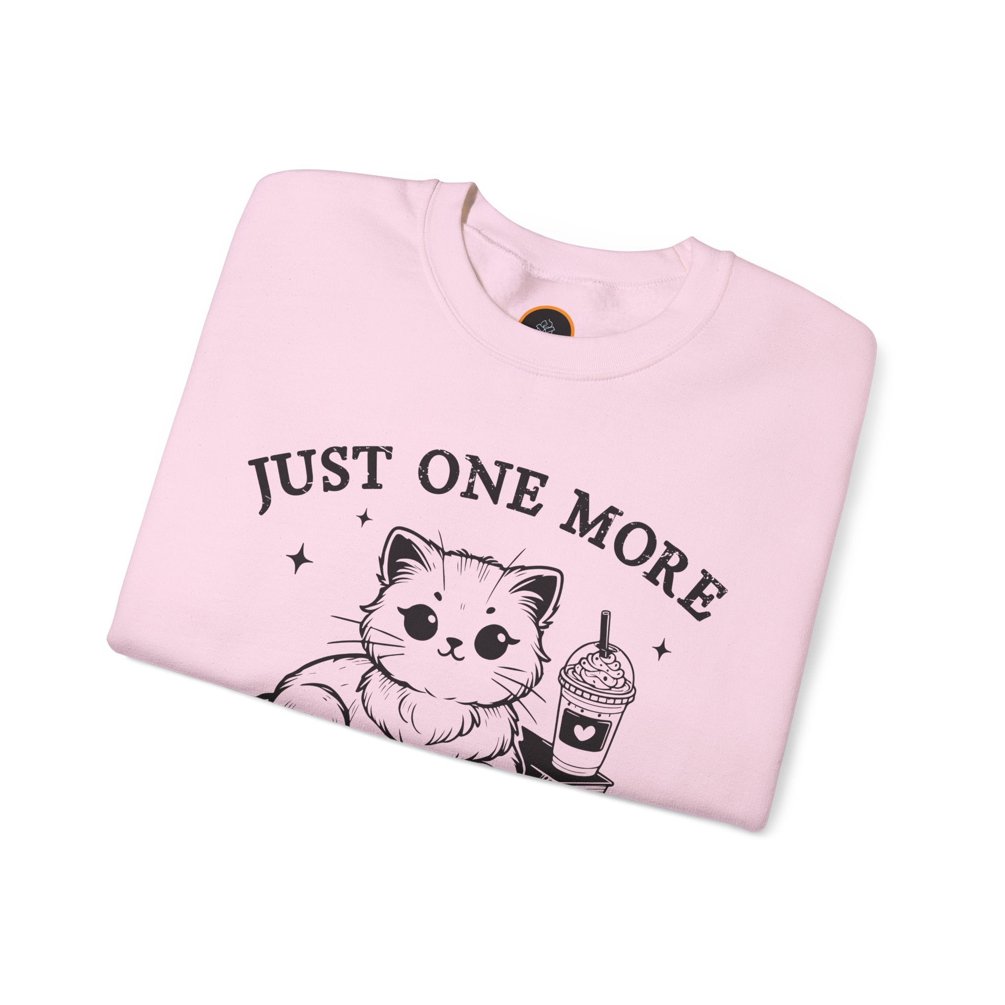 Just One More Chapter" light gray crewneck sweatshirt with a graphic of a cat reading a book next to a Frappuccino on a stack of books.