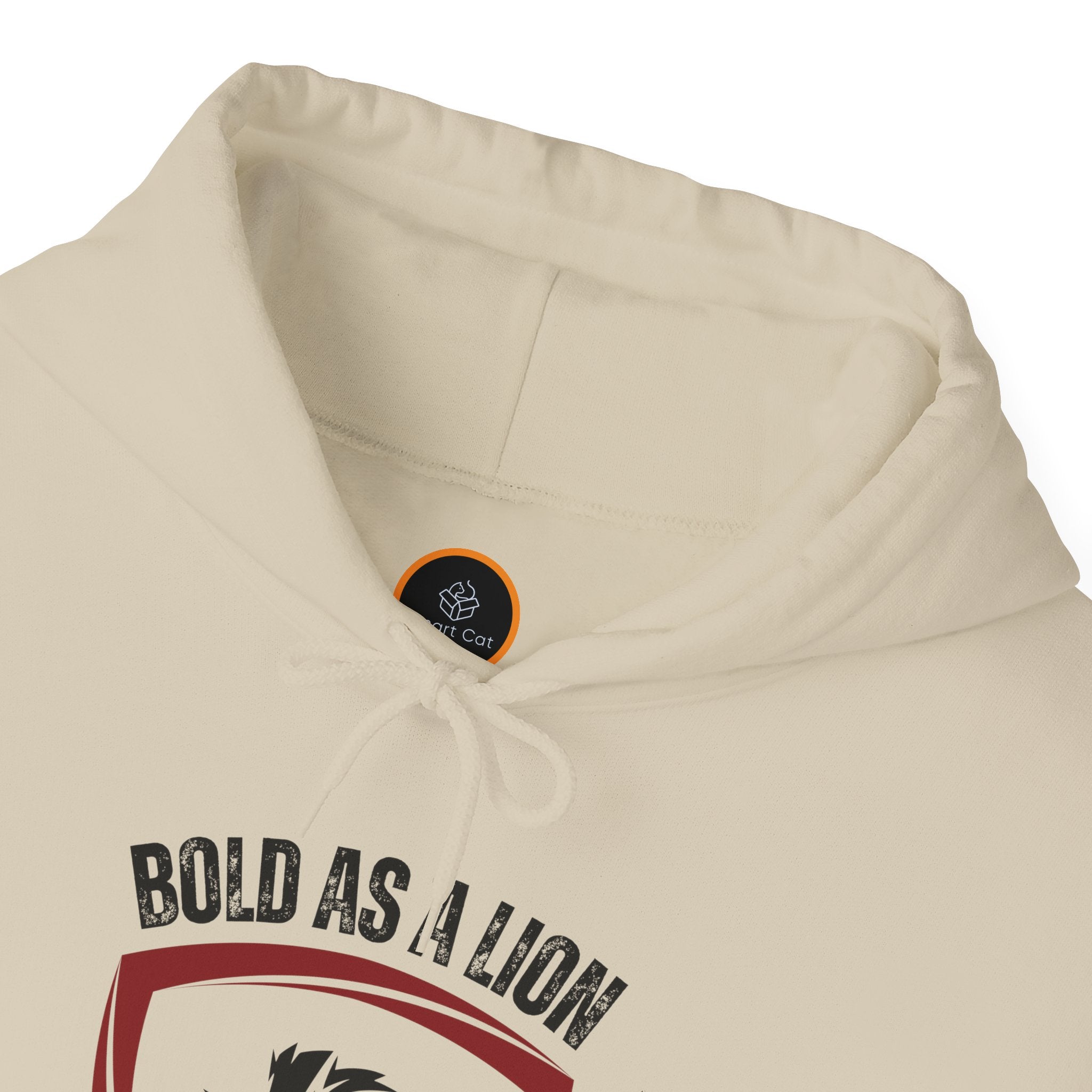 A folded beige hoodie with the text 'Bold As A Lion' written on top. 