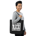 Model wearing a black canvas tote with Peace Love Rescue graphic over her right shoulder