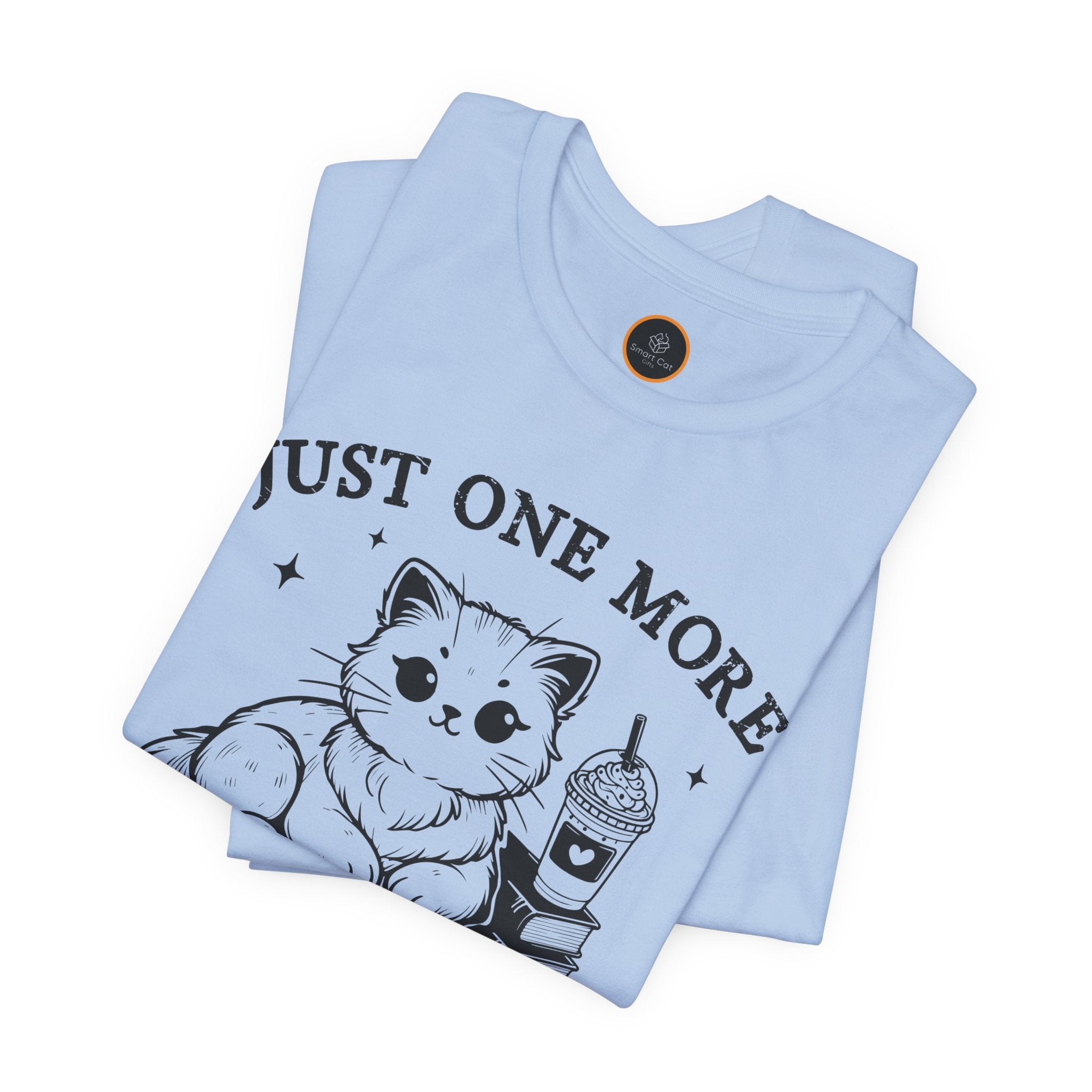 The "Just One More Chapter" t-shirt depicting a cat reading an open book beside a book stack topped with a beverage. The words "just one more" are above, and "chapter" in script is below.