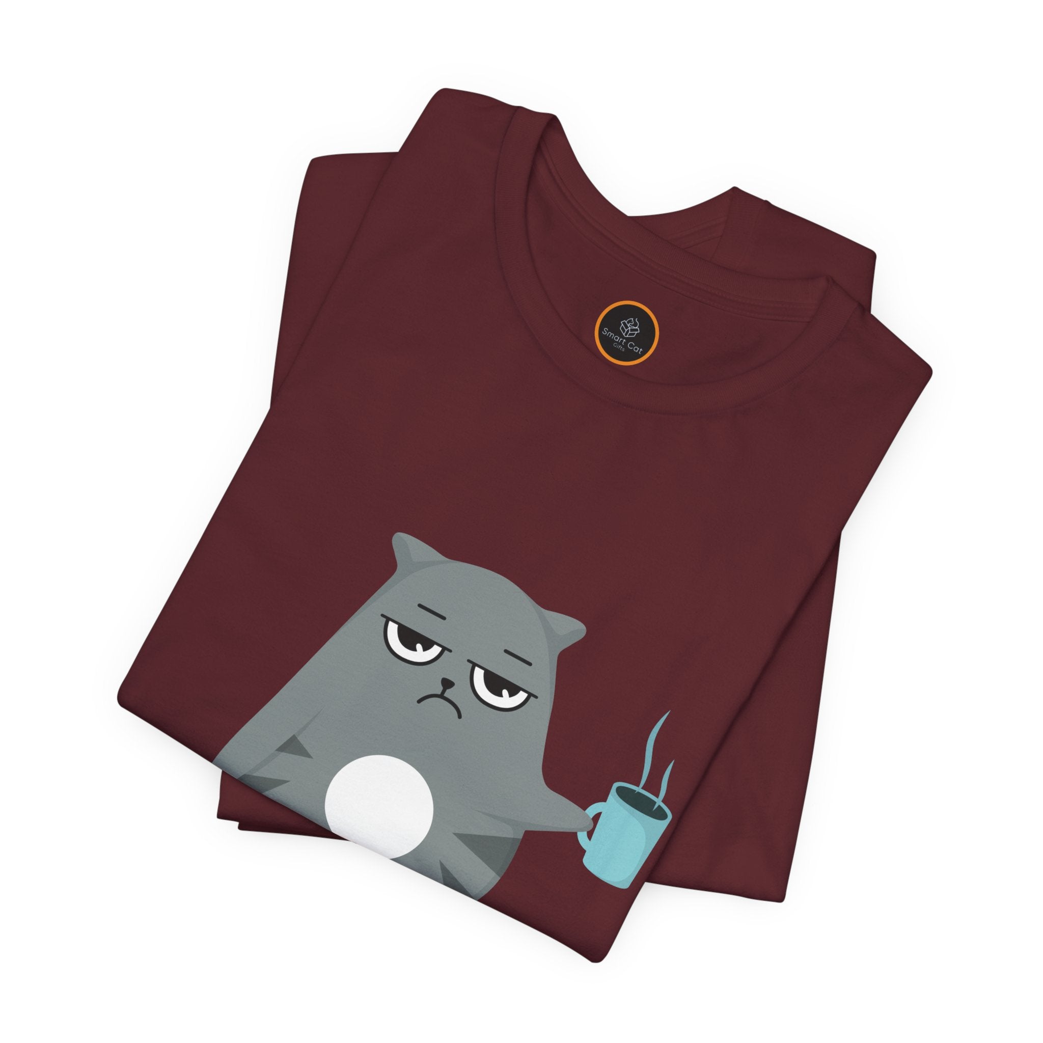 Crewneck t-shirt featuring a cartoon gray and white cat smugly holds a steaming cup of coffee. A green ball of yarn sits on the floor nearby. Below the image, the text reads "We're Out Of Catnip".