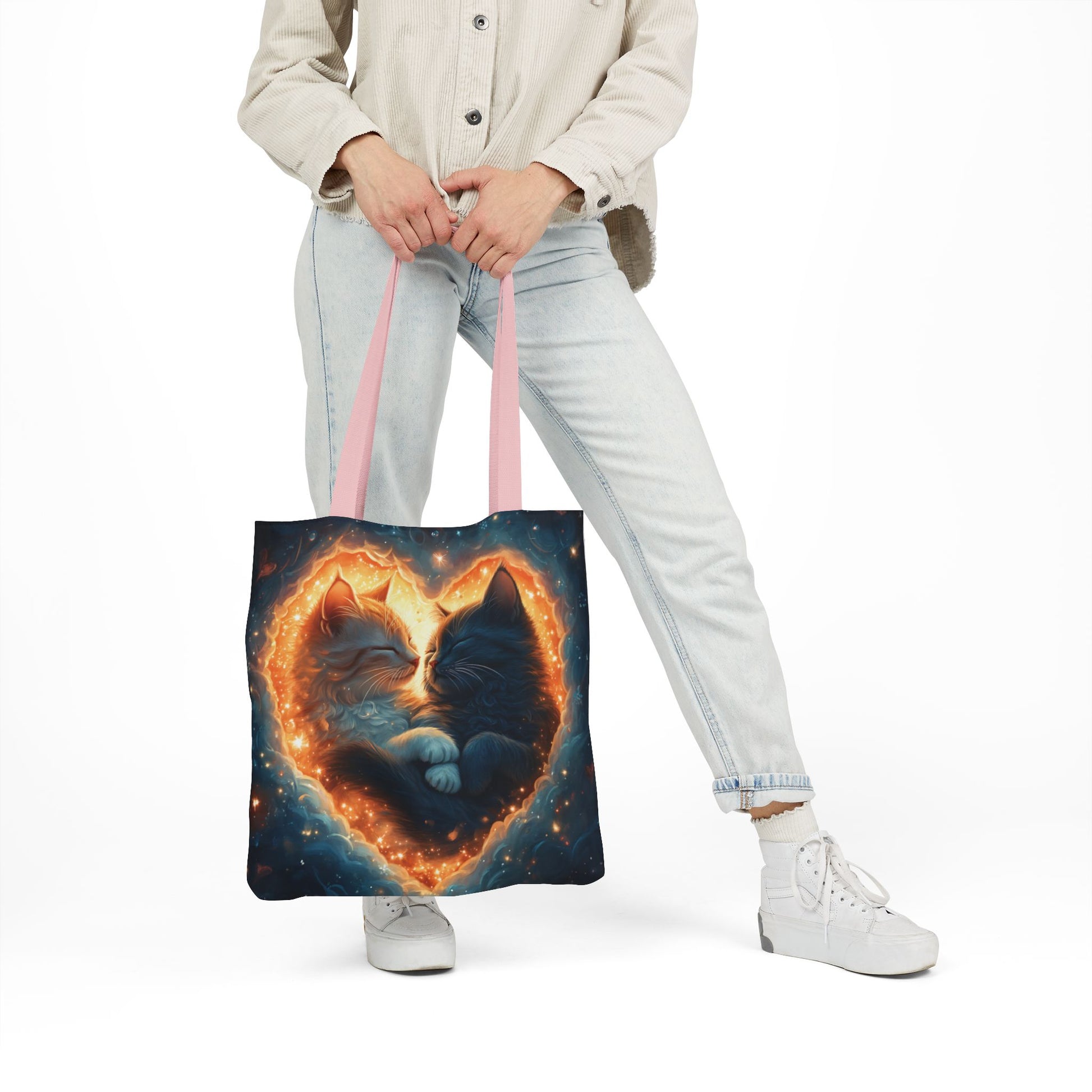 A vibrant heart composed of swirling stardust cradles two cuddling cats against a backdrop of a deep, colorful galaxy. This all-over print design covers the entirety of the Celestial Embrace Tote Bag.