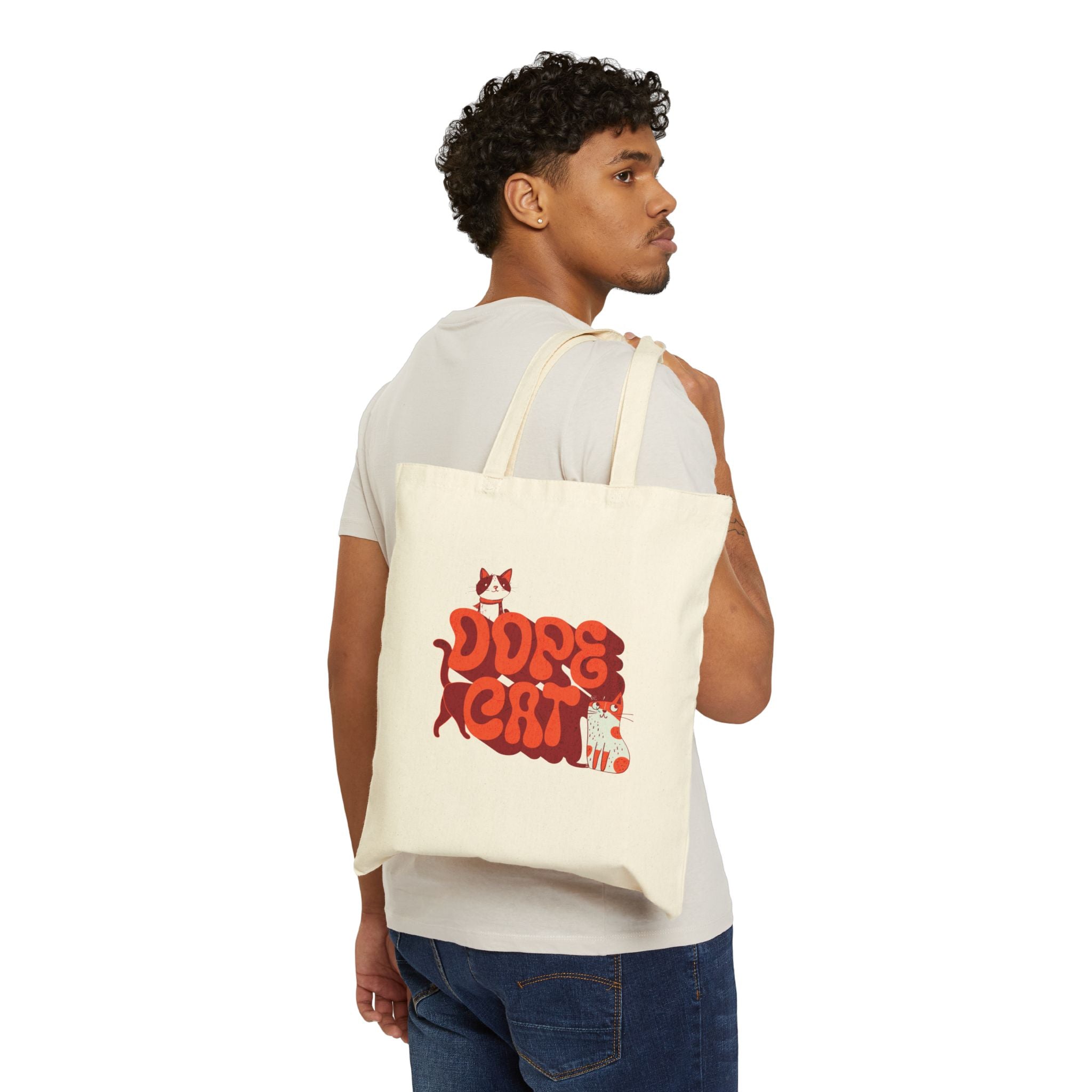 Man holding a beige tote bag with red and white 'Dope Cat' text and cat graphics