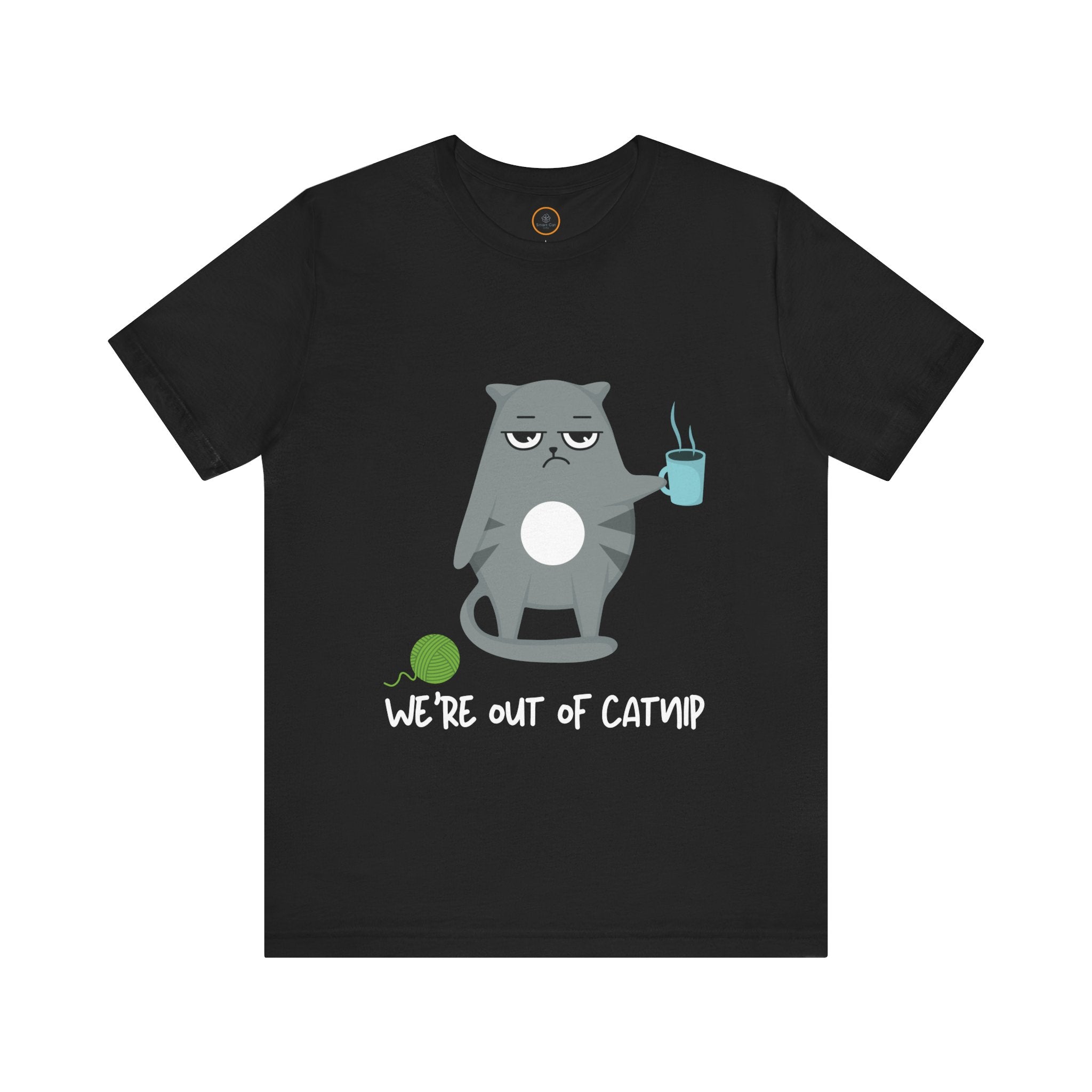 Crewneck t-shirt featuring a cartoon gray and white cat smugly holds a steaming cup of coffee. A green ball of yarn sits on the floor nearby. Below the image, the text reads "We're Out Of Catnip".