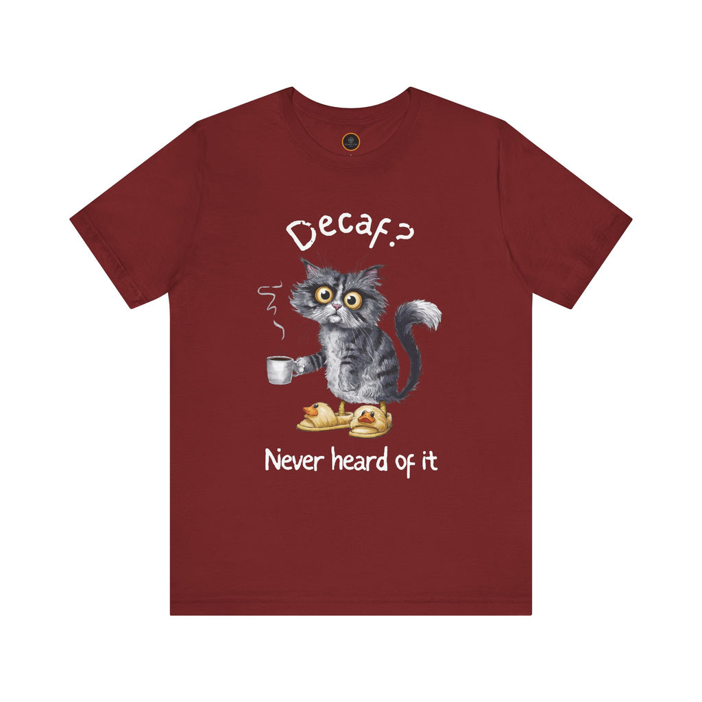 A red crew neck t-shirt featuring an exhausted-looking cat wearing yellow slippers with duck faces on them. The cat is holding a steaming mug of coffee. The text on the sweatshirt reads "Decaf? Never Heard of It."
