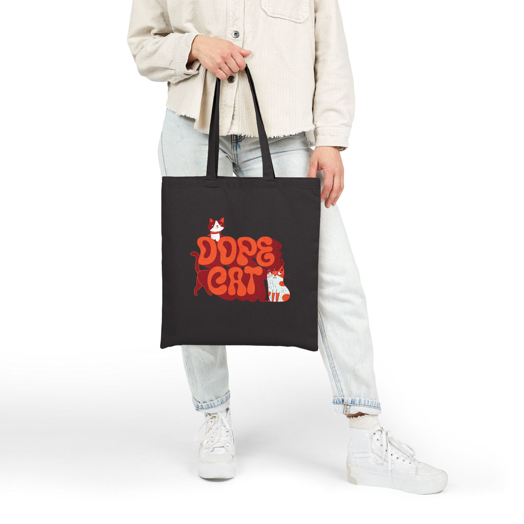 Model holding a black tote bag with red and white 'Dope Cat' text and cat graphics