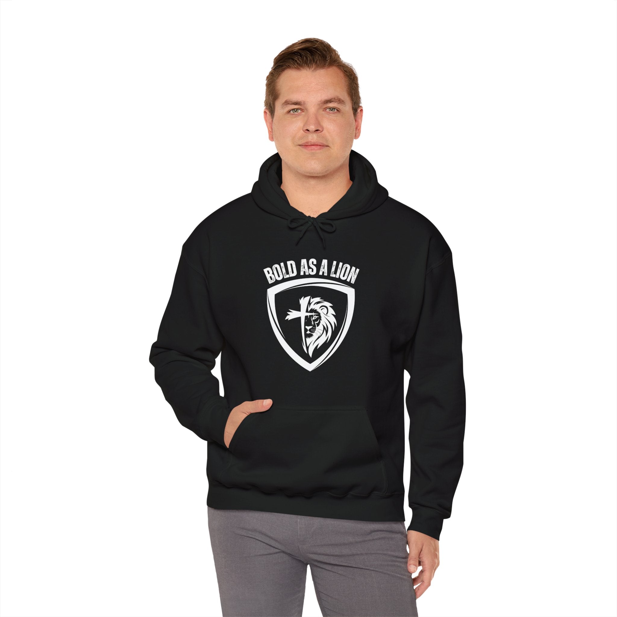 A man models the Bold As A Lion Hoodie. The hoodie features a graphic with half of a lion's face merging into half of a cross within a shield outline. The text "bold as a lion" is printed above the graphic.