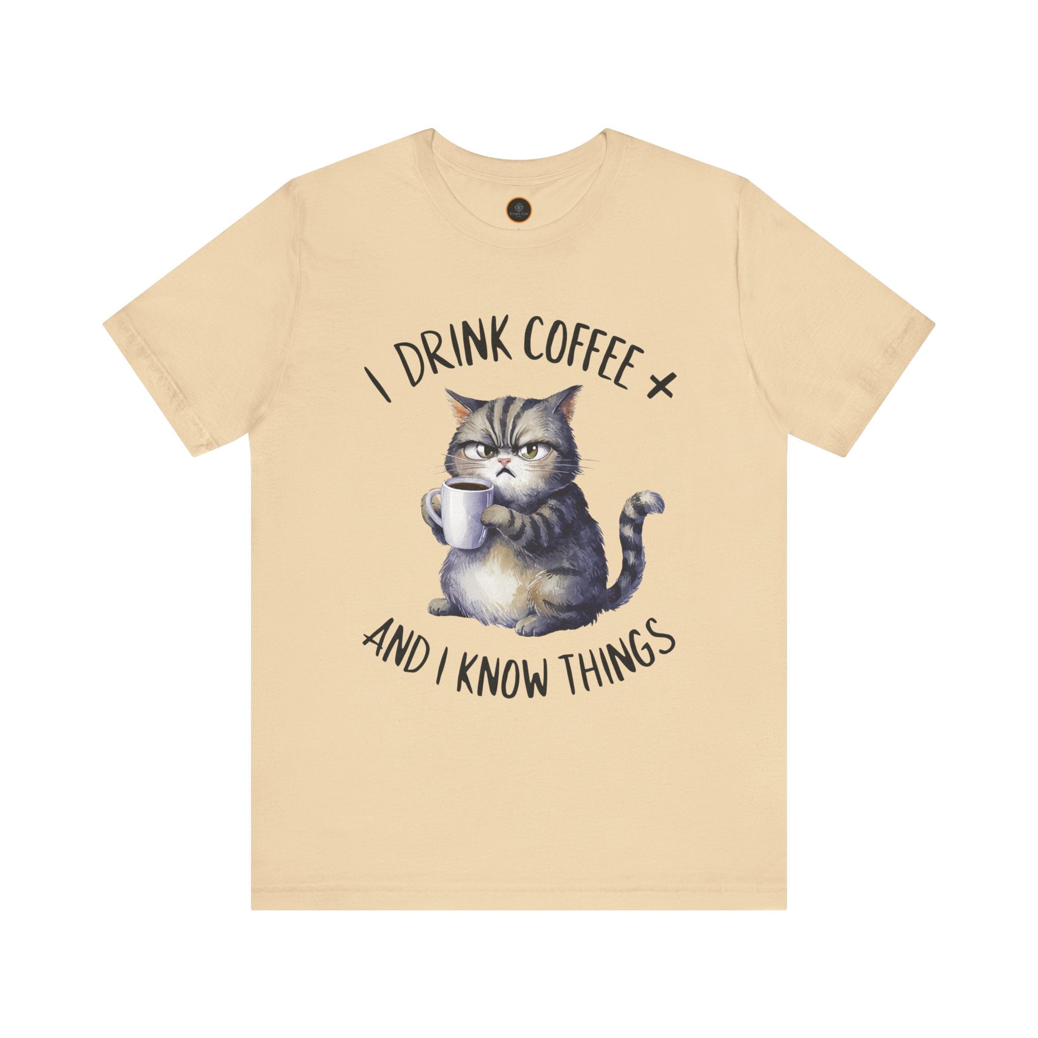 A crew neck t-shirt with the text 'I DRINK COFFEE AND I KNOW THINGS' and an illustration of grumpy a cat holding a coffee cup.