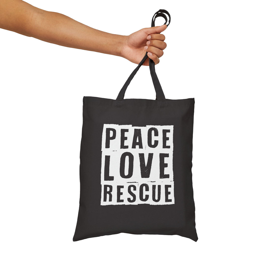 Black canvas tote with Peace Love Rescue graphic held by handles, front view