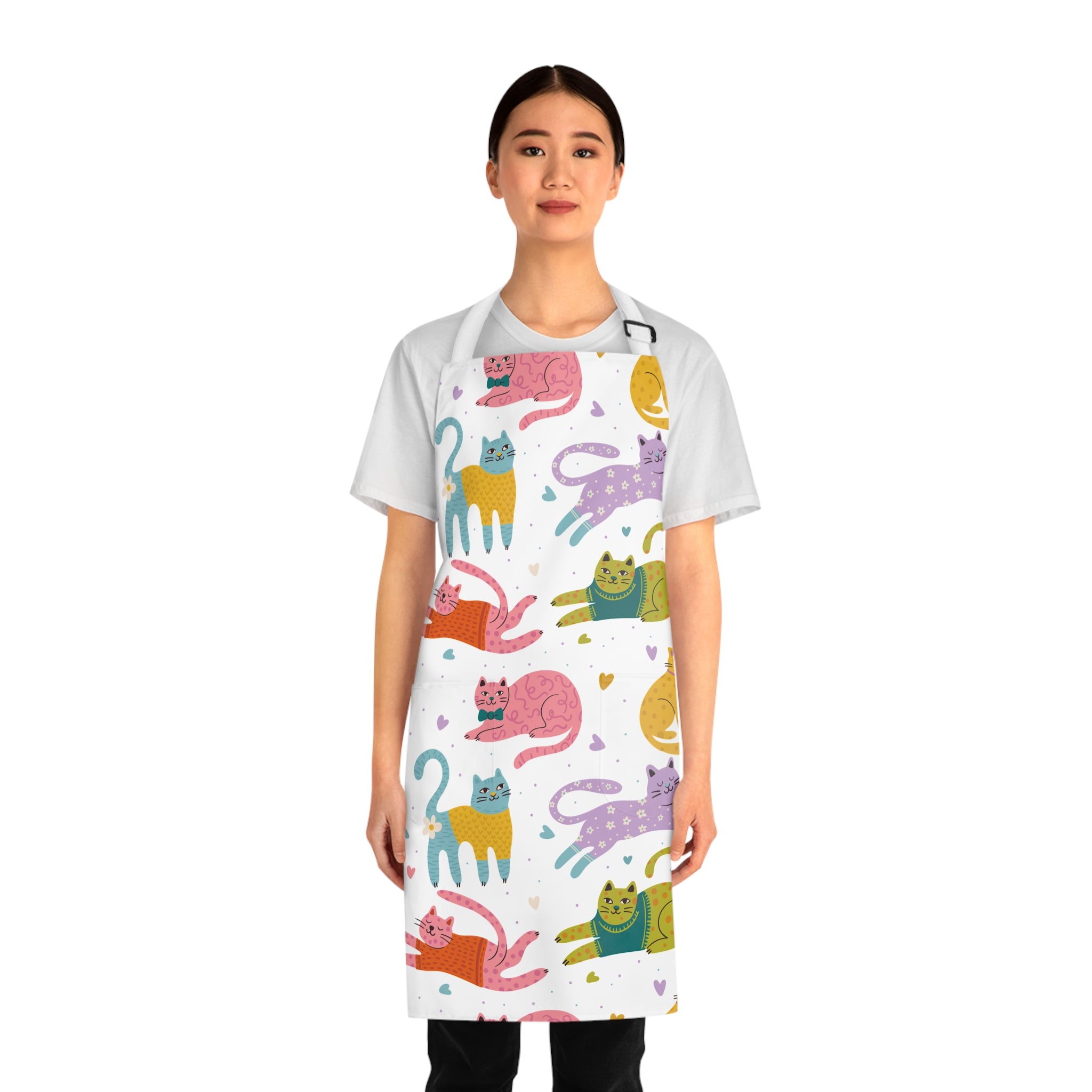 Model wearing a colorful cat-patterned apron on a white background