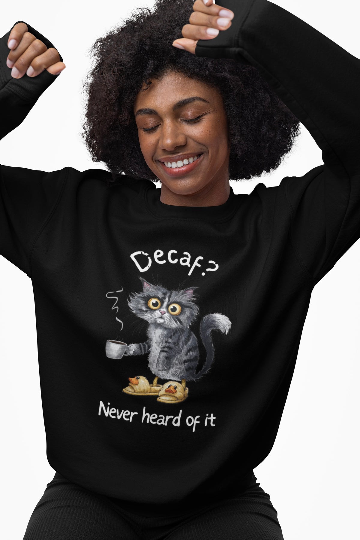 Model wearing black Decaf? Never Heard of It sweatshirt with a tired cat holding coffee