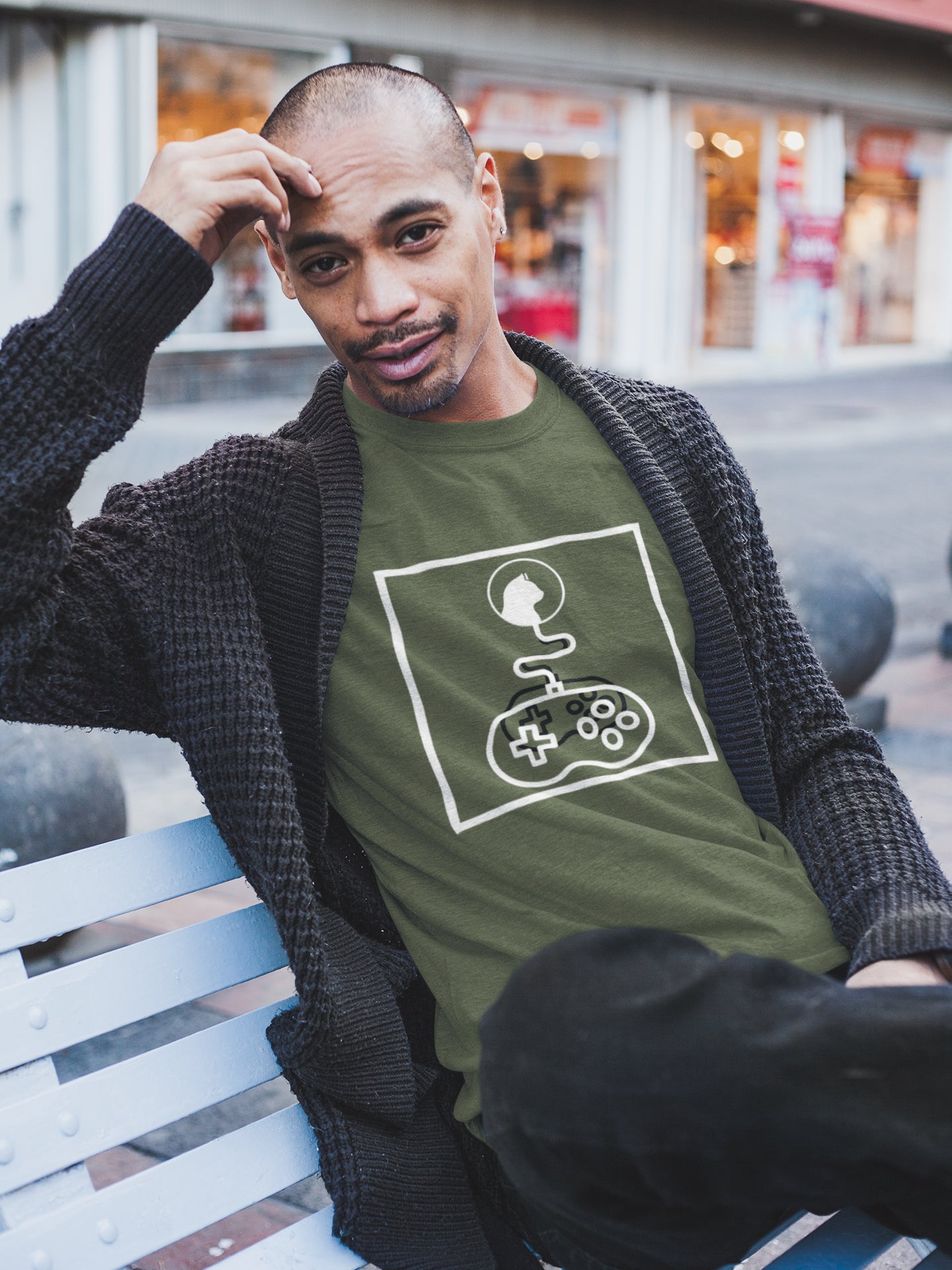 Model wearing a green "System Link Cat" t-shirt: Features a white abstract graphic composed entirely of line art shapes within a box, depicting a cat's head connected by a wire to a video game controller.