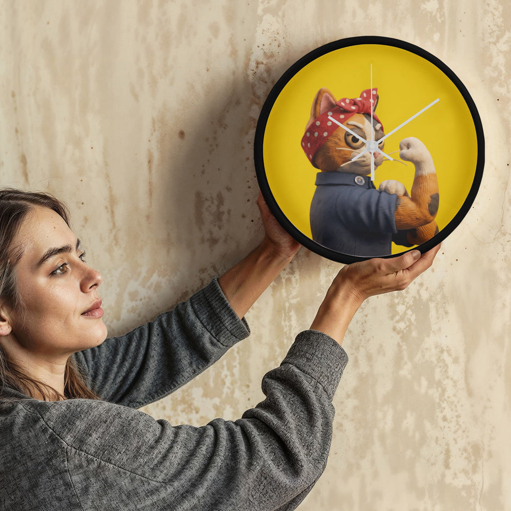 Person mounting yellow Still Fighting wood frame 10" clock onto wall