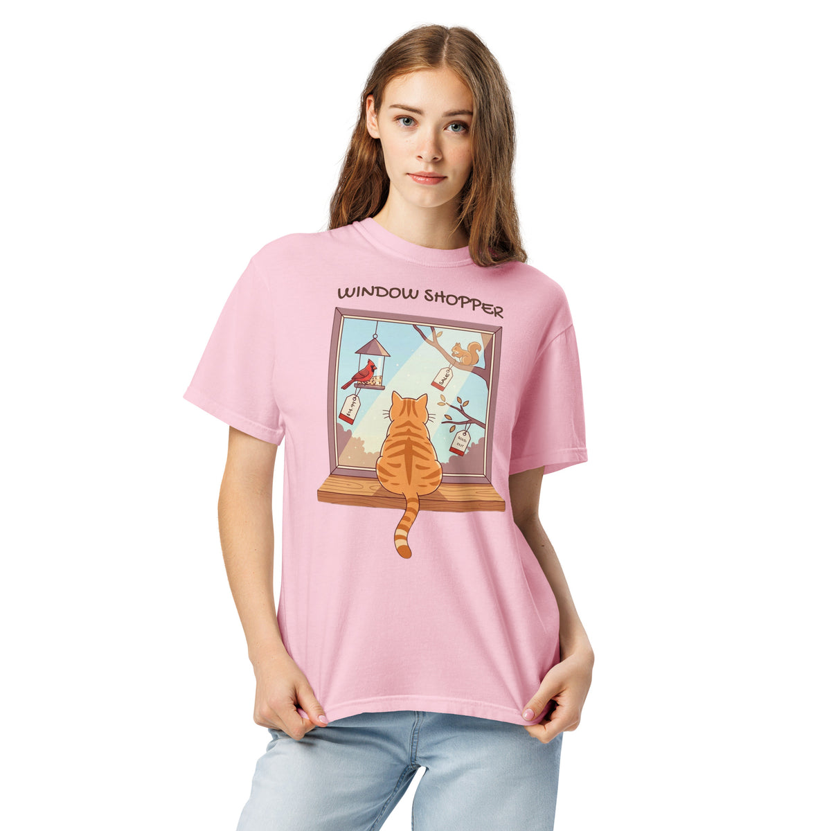 A model wearing the Blossom pink Window Shopper tee, an orange cat at a window watching tagged birds