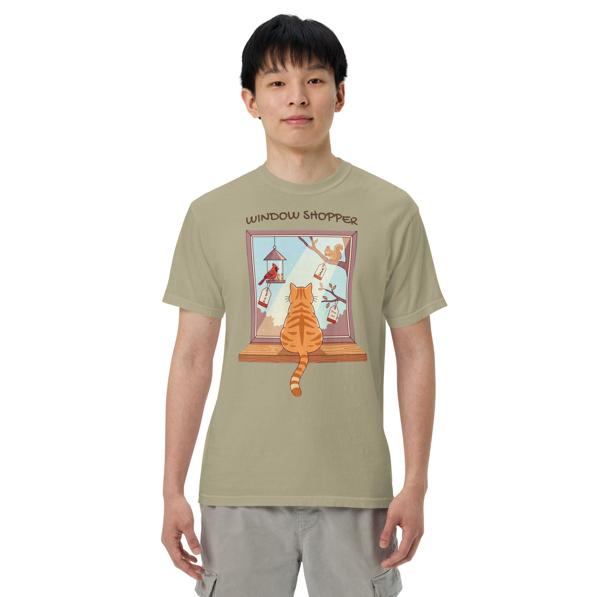A model wearing the Khaki Window Shopper heavyweight t-shirt with an orange cat on a windowsill