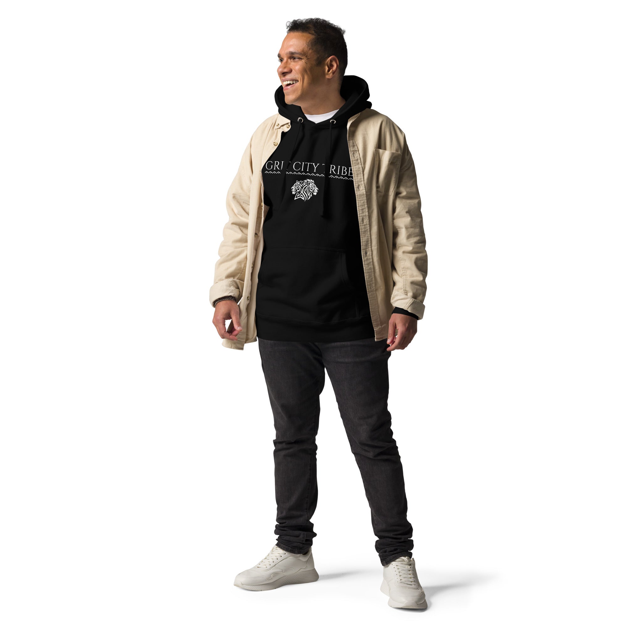Man layering black Grit City Tribe hoodie under tan jacket with dark jeans and white sneakers