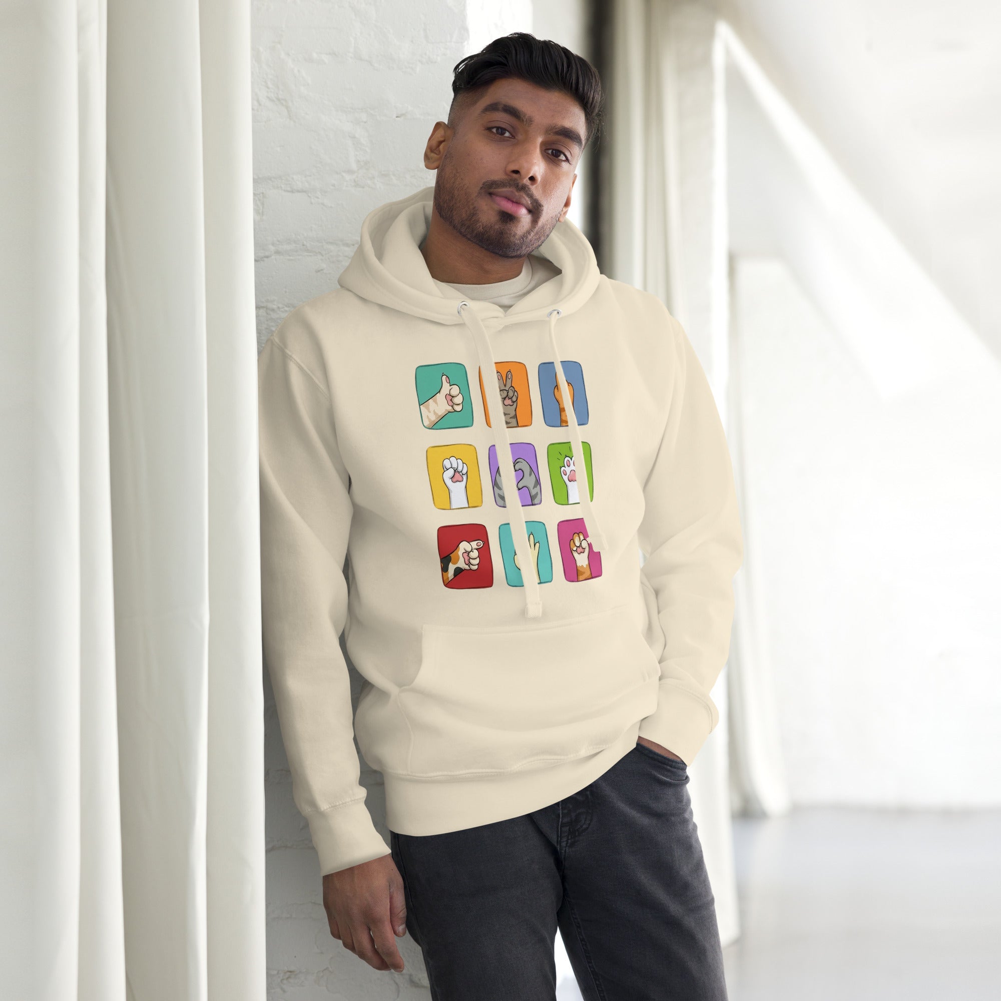 Model wearing cream hoodie with colorful paw signals grid graphic