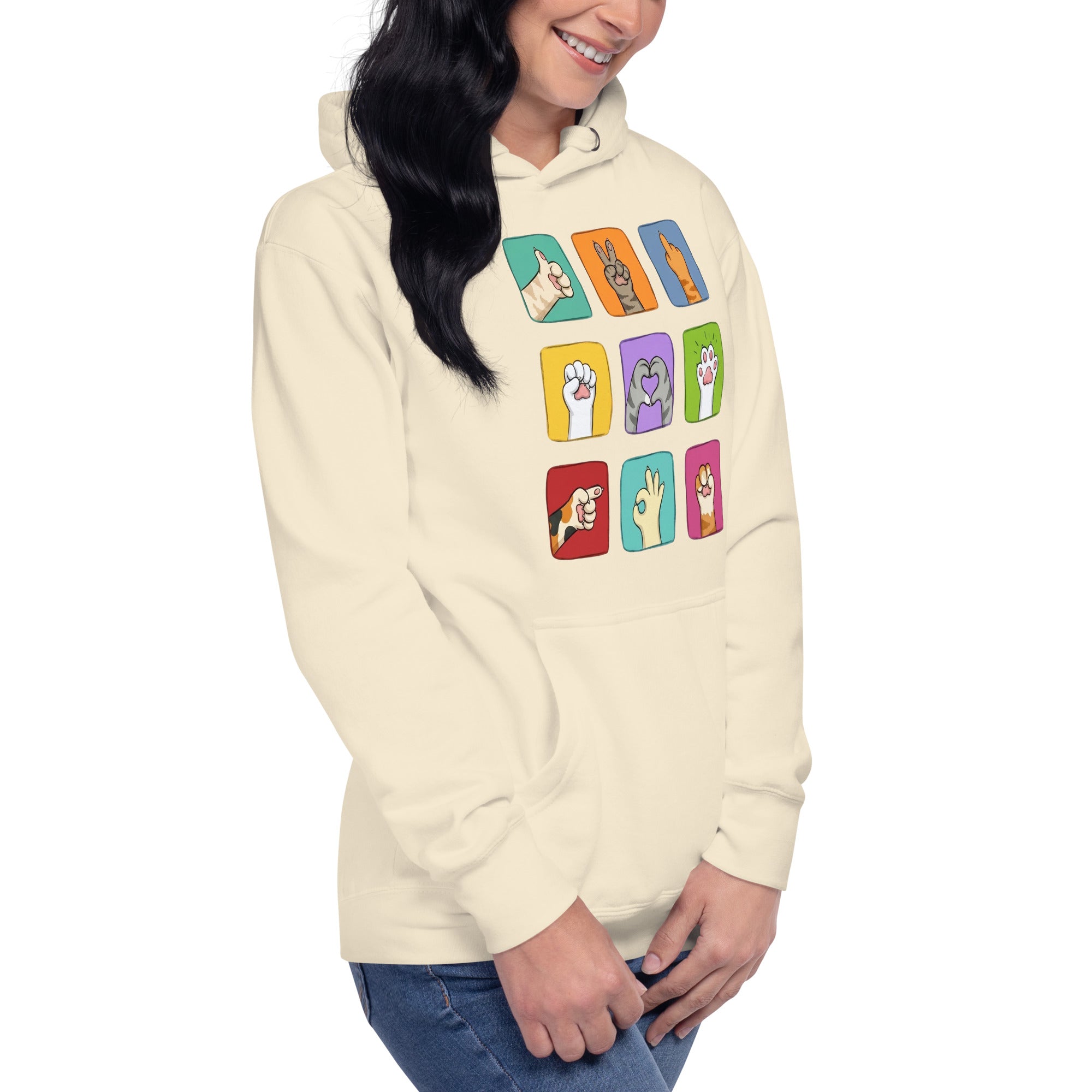Model wearing cream hoodie with colorful paw signals grid graphic, close-up