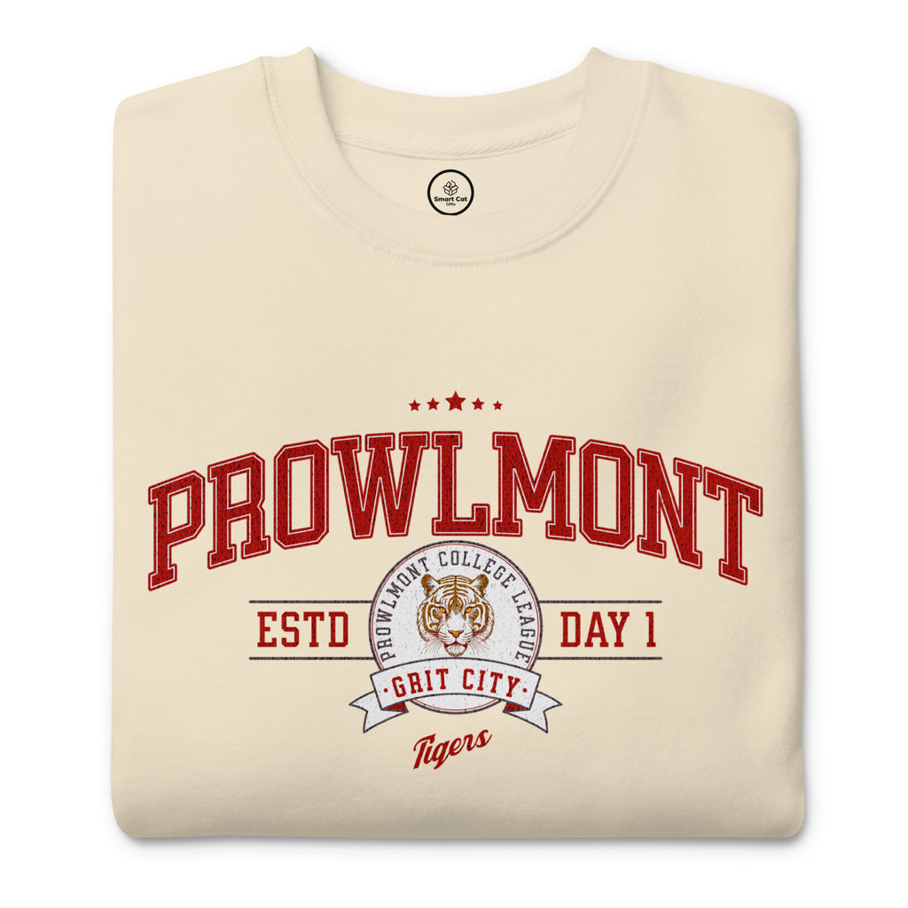 A folded cream-colored t-shirt with a red and white graphic print on the front reading 'PROWLMONT ESTD DAY 1 GRIT CITY Tigers' with a tiger mascot logo.