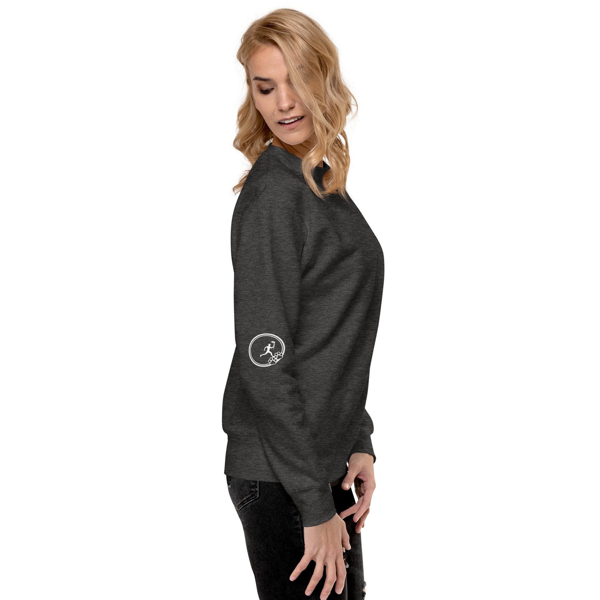 Right side of sweatshirt: Small graphic on right sleeve depicting a man within a circle holding a torch while running towards three paws. 