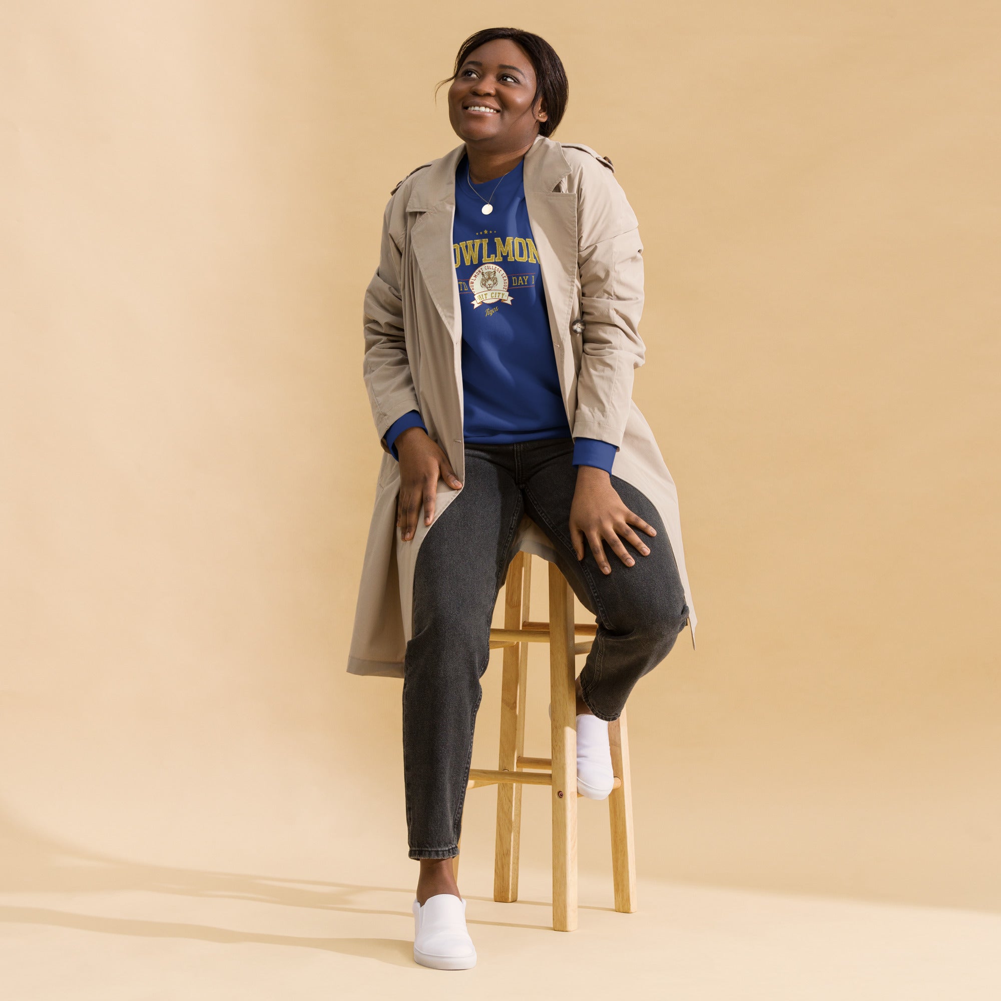 Woman wearing a royal blue varsity style sweatshirt with yellow 'Prowlmont Grit City Tigers' text and tiger logo on a white background