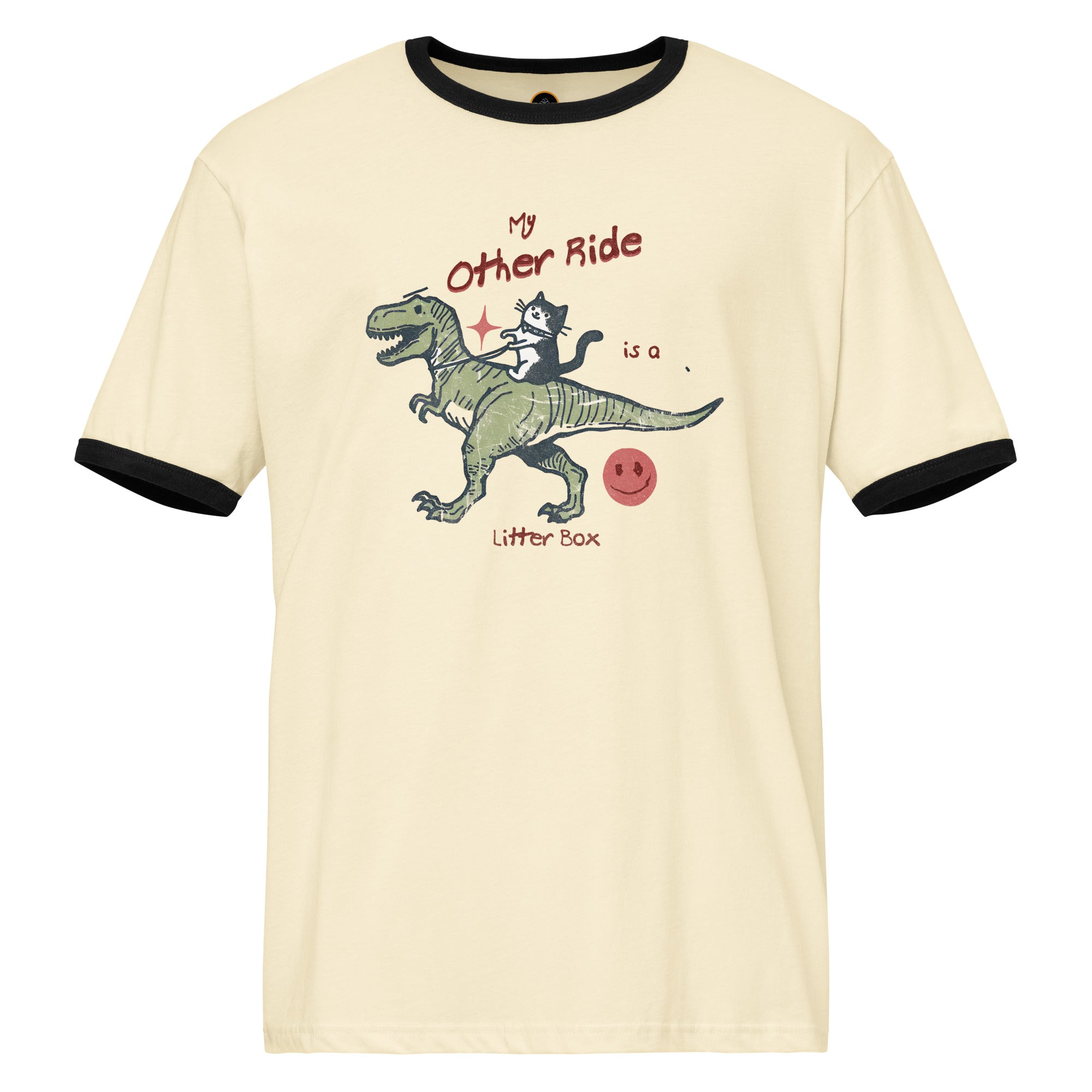 Beige ringer t-shirt with a cat riding a dinosaur  graphic. The text reads 'My other ride is a litter box'.