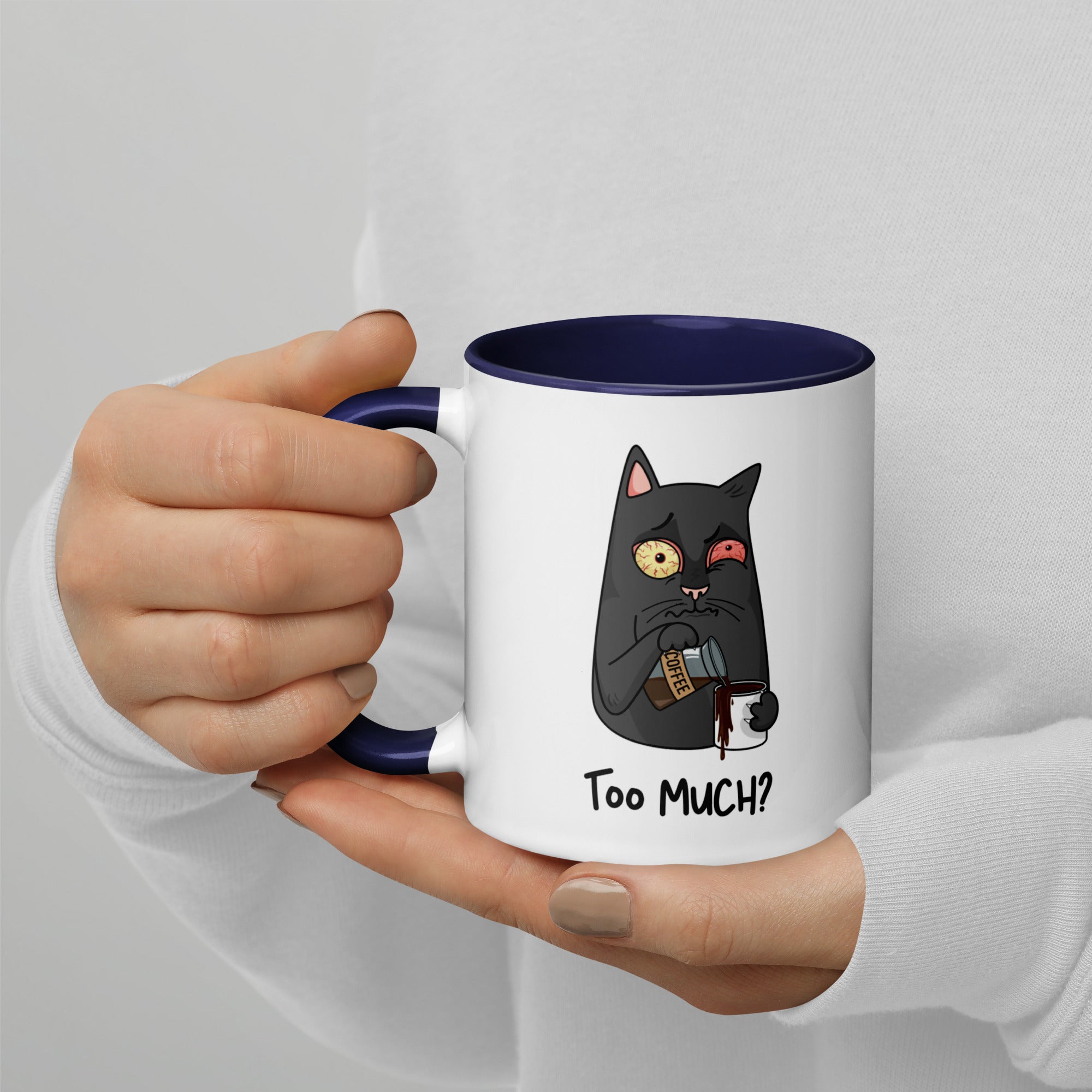 White "Too Much" Mug (showing interior and handle): Graphic of a wide-eyed/red-eyed gray cat pouring overflowing coffee into a cup, with coffee spilling down the side.