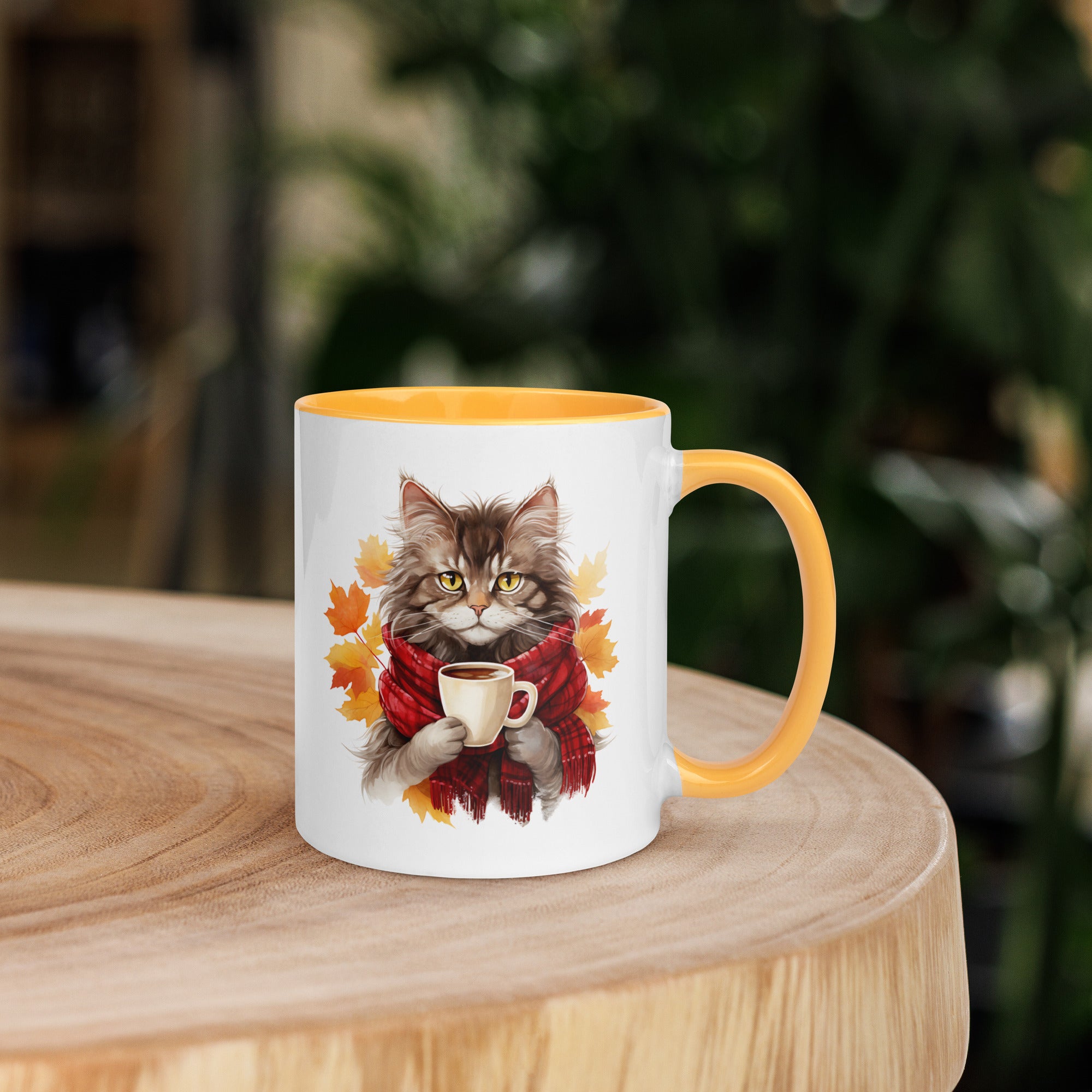 White "Autumn Kitty" Mug with a yellow interior and rim. The graphic shows a cat wearing a plaid scarf and holding a steaming beverage, set against a backdrop of orange and yellow fall leaves.
