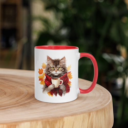 A white ceramic mug with a red rim and handle, featuring an illustration of a cat holding a cup with autumn leaves around it.