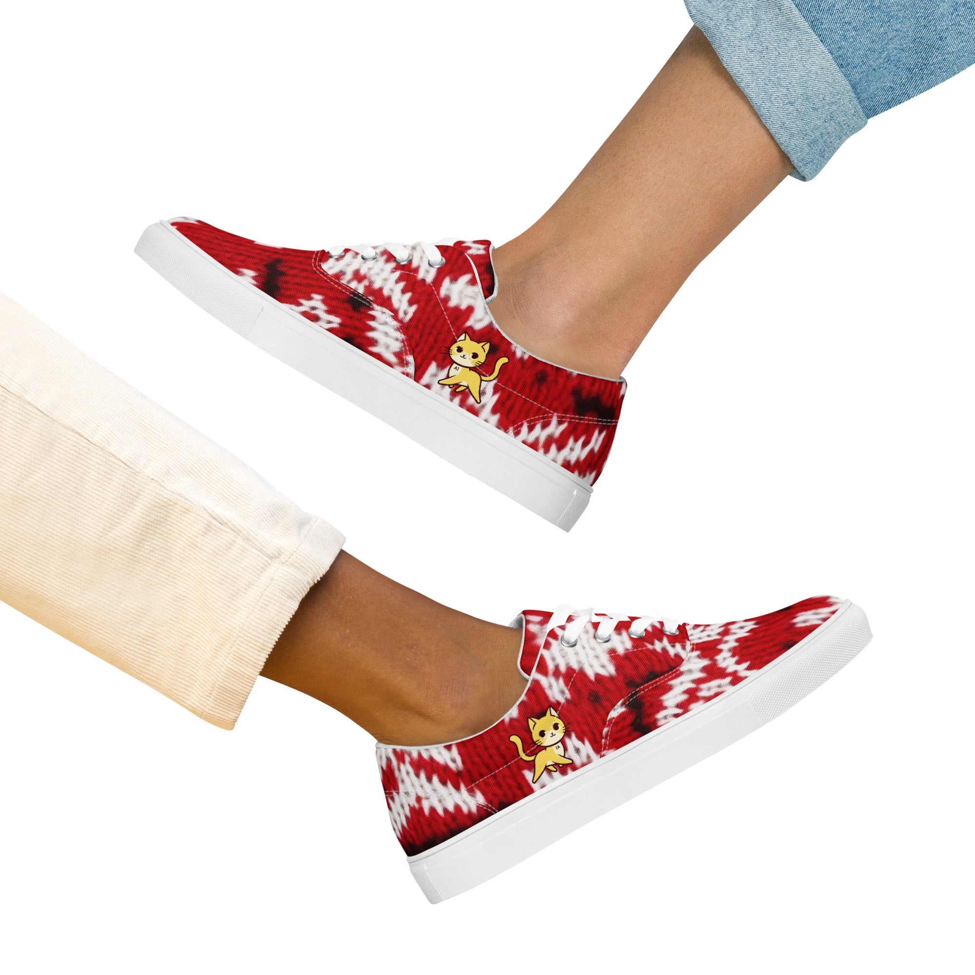 Photo of two women wearing low-top 'Knitty Kitty' sneakers featuring a vibrant red and white knit pattern and a playful yellow cat design.